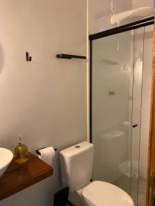 a bathroom with a toilet and a glass shower at Refugio Aconchegante2 in Nova Mutum +2 photos
