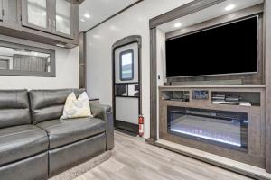 a living room with a couch and a flat screen tv at Roam sweet roam in Ellenton