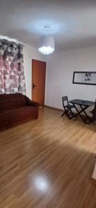 an empty living room with a couch and a table at Apartamento Tranquilidade! in Uberaba