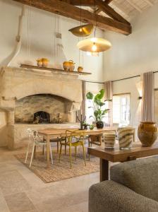 a living room with a table and a stone fireplace at Maison Girardine in Rauzan