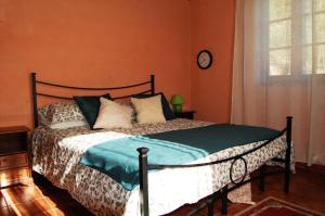 1 dormitorio con 1 cama y reloj en la pared en Casa Ulqini en Bagni di Lucca