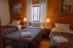 a room with two beds and a window at Hotel de la Costa in Talcahuano