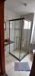 a glass shower in a bathroom with a tile floor at Apartamento Tranquilidade! in Uberaba +7 photos