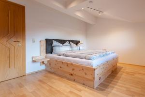 a bedroom with a wooden bed with a wooden floor at Mountain Apex in Dölsach