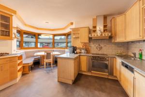 a kitchen with wooden cabinets and a dining room at Mountain Apex in Dölsach