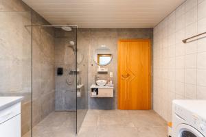 a bathroom with a shower and a wooden door at Mountain Apex in Dölsach +51 photos