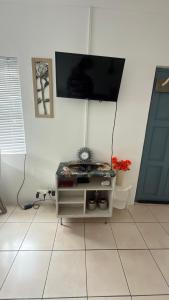 a living room with a tv on a white wall at Vicky holiday home in Walvis Bay +5 photos