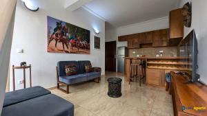 a living room with a couch and a kitchen at Chic studio with parking & balcony in Yaoundé