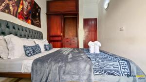 a bedroom with a large bed in a room at Chic studio with parking & balcony in Yaoundé +5 photos