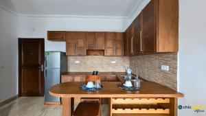 a kitchen with wooden cabinets and a wooden table at Chic studio with parking & balcony in Yaoundé