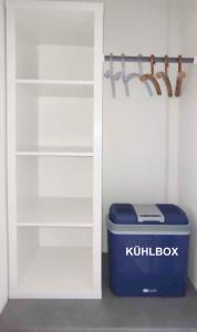 a white closet with a blue cooler and a shelf at Zimmer mit Terrasse am Jakobsberg in Ockenheim