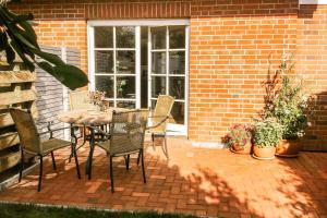 a patio with a table and chairs in front of a brick house at Kira in Börzow