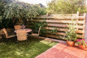 a patio with a table and chairs in front of a fence at Kira in Börzow