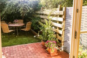 a patio with a table and some plants and a fence at Kira in Börzow