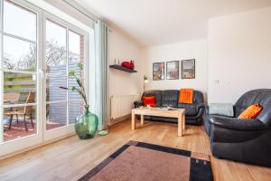 a living room with two couches and a table at Kira in Börzow +18 photos