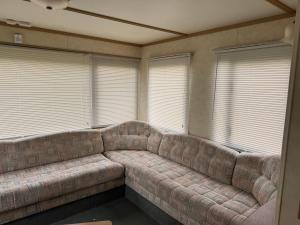 a large couch in a room with windows at T & L CARAVANs in Skegness