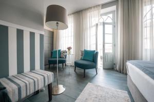 a bedroom with a bed and two chairs and a table at Santo Thyrso Villas in Santo Tirso +16 photos