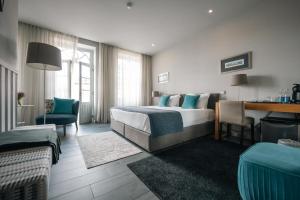 a hotel room with a bed and a desk at Santo Thyrso Villas in Santo Tirso