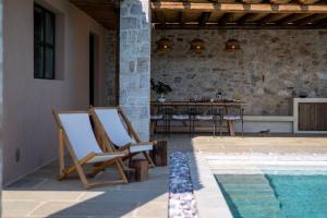 a patio with a table and chairs next to a pool at The sagehill-stonehouse in Mathía