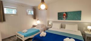 a bedroom with two beds and a pendant light at Ragousis Apartments in Parikia