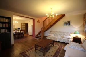 a living room with a staircase and a couch at Leygat in Solignac