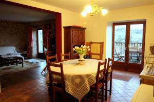 a dining room with a table with a vase of flowers on it at Leygat in Solignac