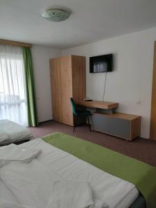 a bedroom with a bed and a desk with a television at Casa Rares in Moieciu de Sus