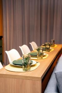 a long wooden table with plates and glasses on it at Studio River 101 in Pôrto de Pedras +87 photos
