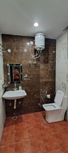 a bathroom with a toilet and a sink at Hanumant Dham in Dārāganj