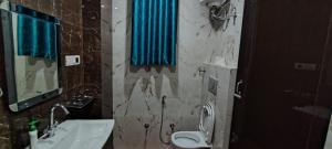 a bathroom with a sink and a toilet and a mirror at Hanumant Dham in Dārāganj