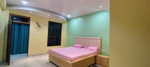 a bedroom with a bed with pink sheets on it at Hanumant Dham in Dārāganj