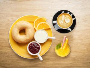a table with a plate with a doughnut and a drink at easyHotel Amsterdam Zaandam in Zaandam
