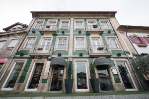 a green and white building with windows and balconies at Santo Thyrso Villas in Santo Tirso