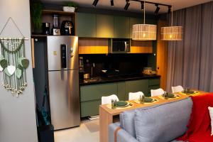 a kitchen with a stainless steel refrigerator and a table at Studio River 101 in Pôrto de Pedras