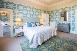 a bedroom with a large bed with blue and white sheets at 7 Howard Place in St. Andrews