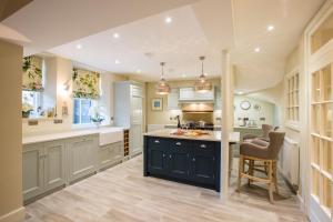 a large kitchen with a blue island and chairs at 7 Howard Place in St. Andrews