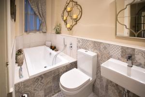 a bathroom with a toilet and a tub and a sink at 7 Howard Place in St. Andrews +22 photos