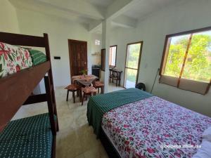 a bedroom with a bed and a table in it at Boipeba casa de un ambiente in Cairu