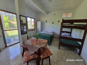 a room with a bed and a table and bunk beds at Boipeba casa de un ambiente in Cairu