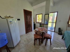 a kitchen with a table and a refrigerator at Boipeba casa de un ambiente in Cairu