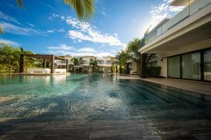a swimming pool in front of a house at Elegant Villa with Poolfront View in Monterrico