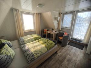 a bedroom with a bed and a desk and windows at Zingster Ostseeklause in Zingst
