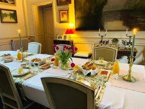 a dining room with a table with food on it at Le Manoir des Doyens in Bayeux