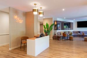 a lobby with a reception desk and a living room at Hôtel Bahia in Villeneuve-Loubet