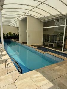 a large swimming pool with an open ceiling at Studio no Coração do Jardins Moderno e Sofisticado in São Paulo