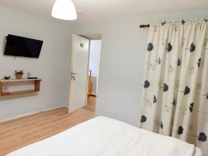 a bedroom with a bed and a television on a wall at Trakos Home Hotel in Korçë