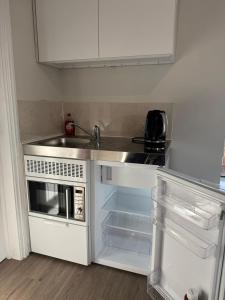a small kitchen with a sink and a microwave at Central Aldershot Flat, Near Station & Town Centre in Aldershot