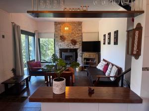 a living room with a table and a fireplace at La Morondanga in Villa Yacanto