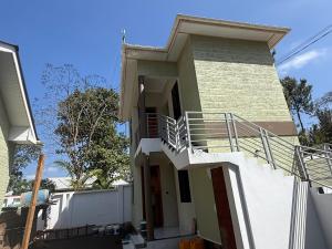 a house with stairs on the side of it at Safari Haven Villa in Moshi +6 photos
