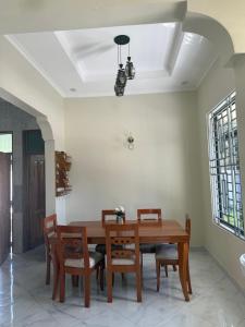 a dining room with a wooden table and chairs at Safari Haven Villa in Moshi